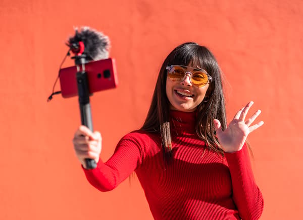 A young woman in red taking a selfie.