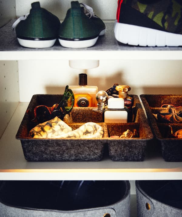 Accessories in a low wardrobe compartment lit up by a battery-powered LED spot placed on the underside of the shelf above.