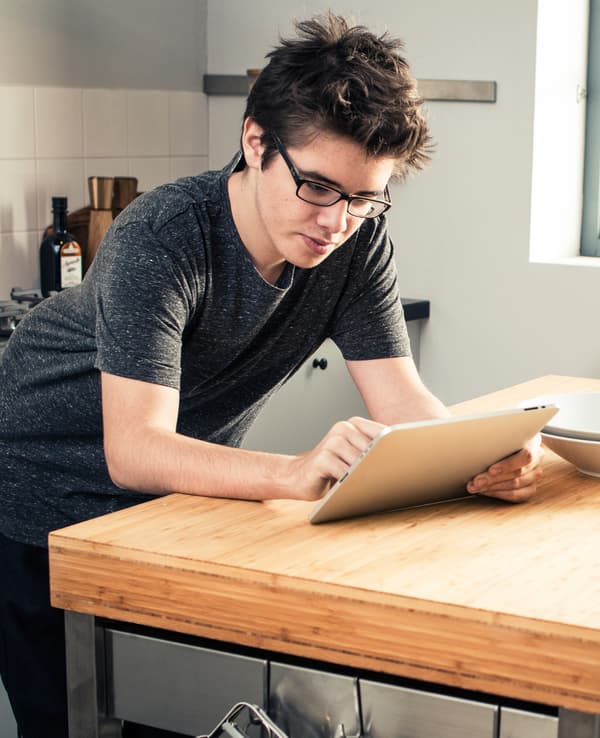 Ado en train d'utiliser une tablette en cuisine