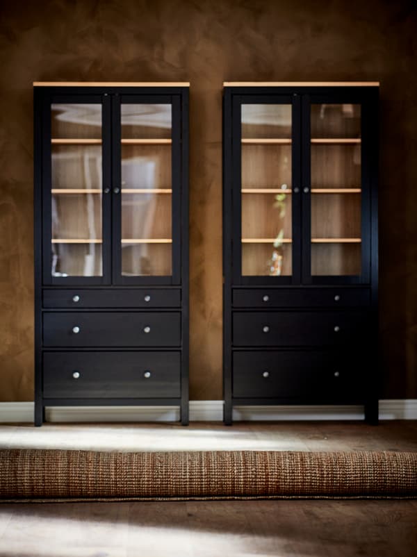 Ambal LOHALS yang digulung terletak di atas lantai kayu, sepasang kabinet berpintu kaca yang kosong bersandar pada dinding berwarna coklat di belakang.