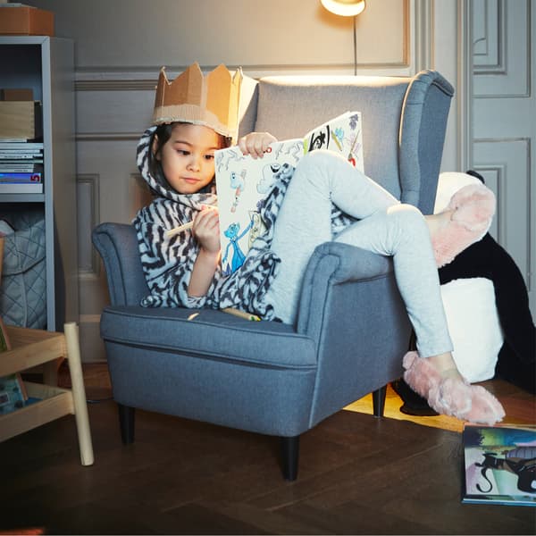 Aménagez un coin lecture cosy pour les enfants. Grâce à la version miniature de l’élégant fauteuil IKEA STRANDMON en gris, par exemple