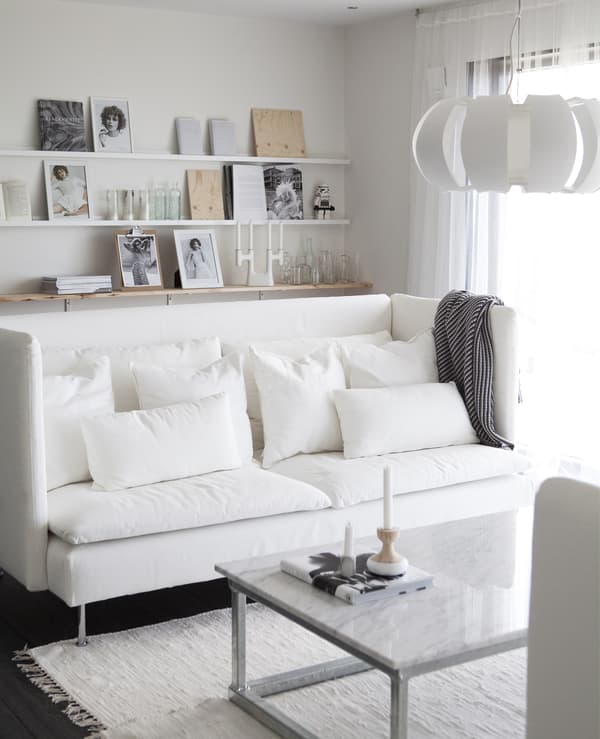 An all-white room with white sofa and textiles.