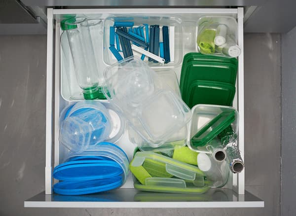 An animated GIF of organising a kitchen drawer full of plastic storage boxes, bottles, aluminium foil and more.