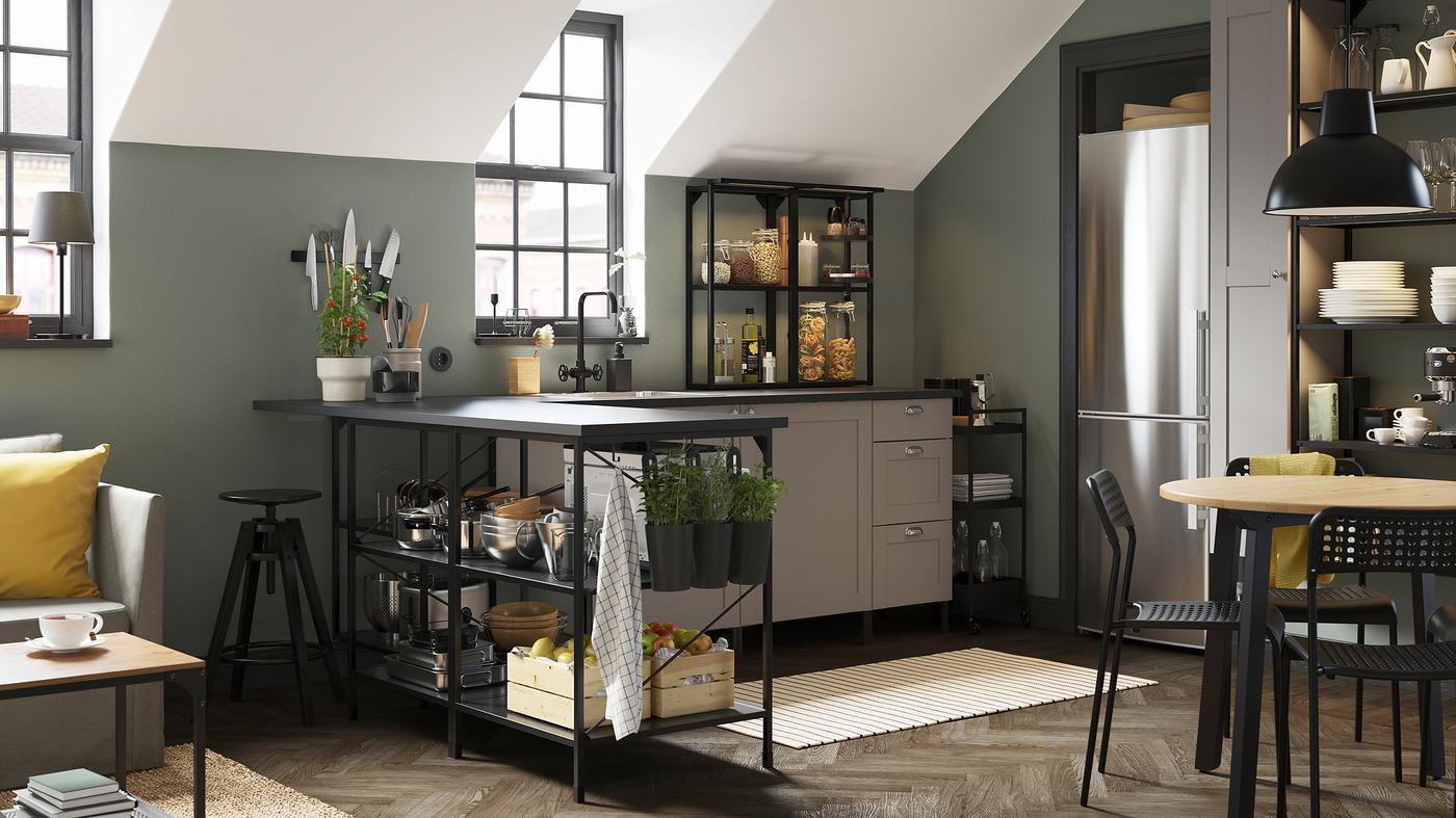 An anthracite/grey corner kitchen, a black trolley, a striped rug and black containers with fresh herbs.