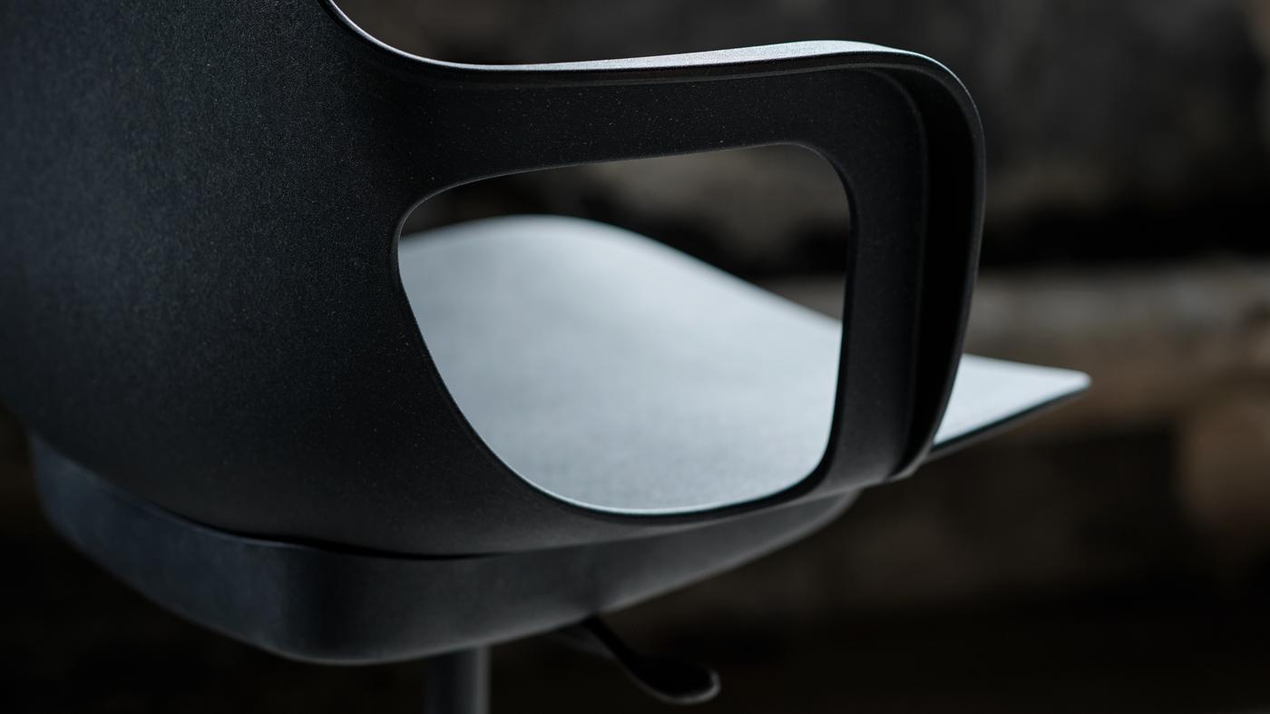 An anthracite ODGER swivel chair standing in a dimly lit room.