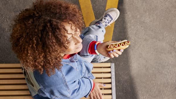 An arial view of a person holding a hot dog