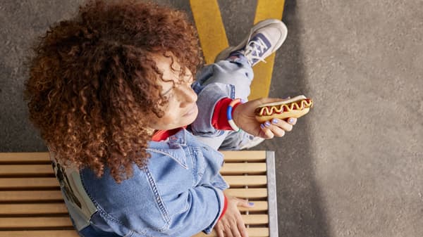 An arial view of a person holding a hot dog