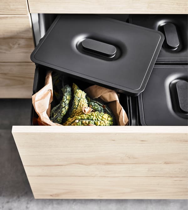 An ash effect drawer filled with waste sorting bins under a kitchen sink