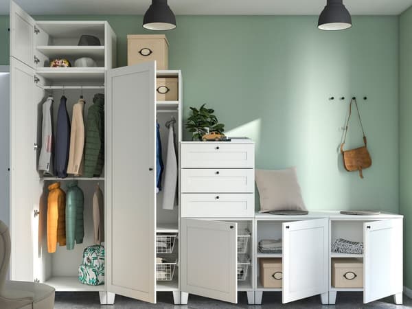 An einer grünen Wand steht eine PLATSA Kombination mit Kleidung und Boxen