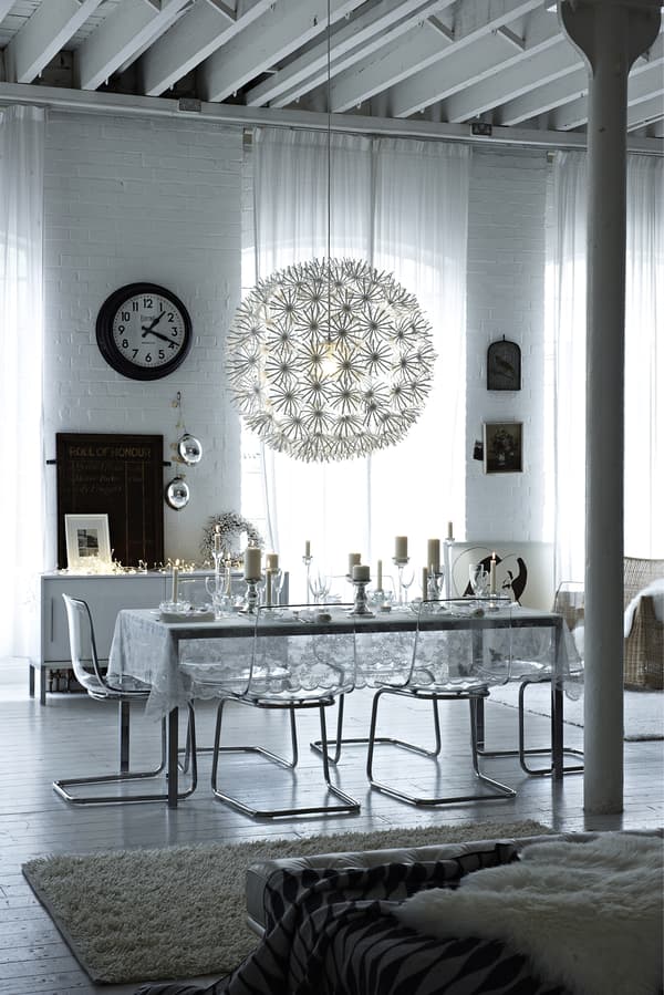 An icy cool glass-effect dining room with a snowball lampshade and a large white rug.