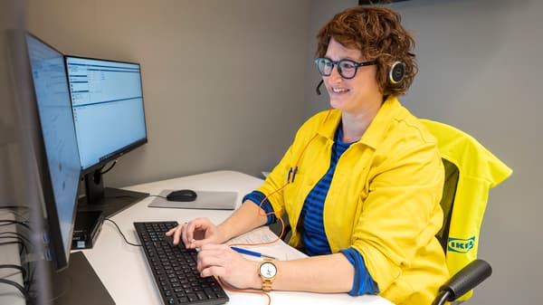 An IKEA co-worker dealing with a customer inquiry at an IKEA service desk.
