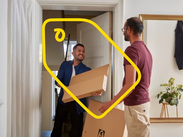 An IKEA co-worker delivering flat pack boxes to a customer's house.