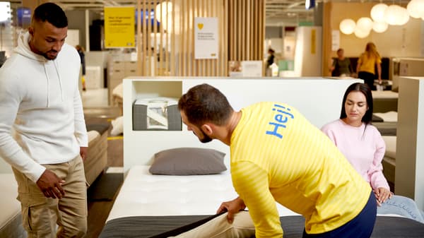 An IKEA co-worker helping customers choose their new mattress.