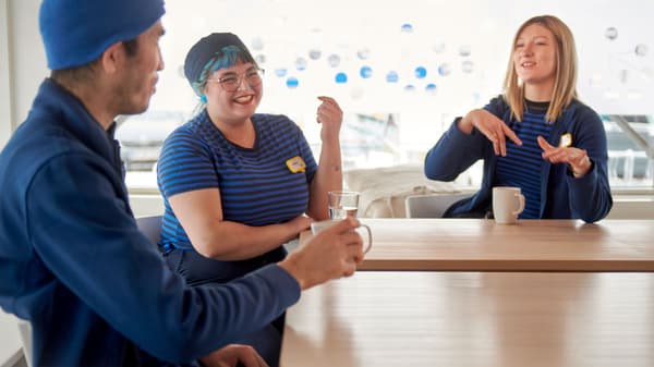 An IKEA co-worker wearing a yellow uniform with the word “Hej!” on the back of the shirt.