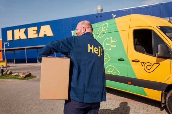 An IKEA employee carrying a Post package