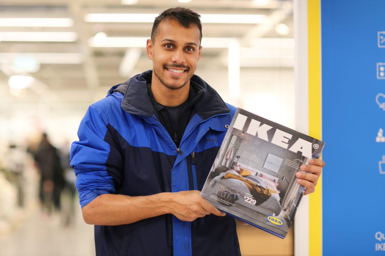 An IKEA Family member holding his IKEA Coffee Table Catalogue