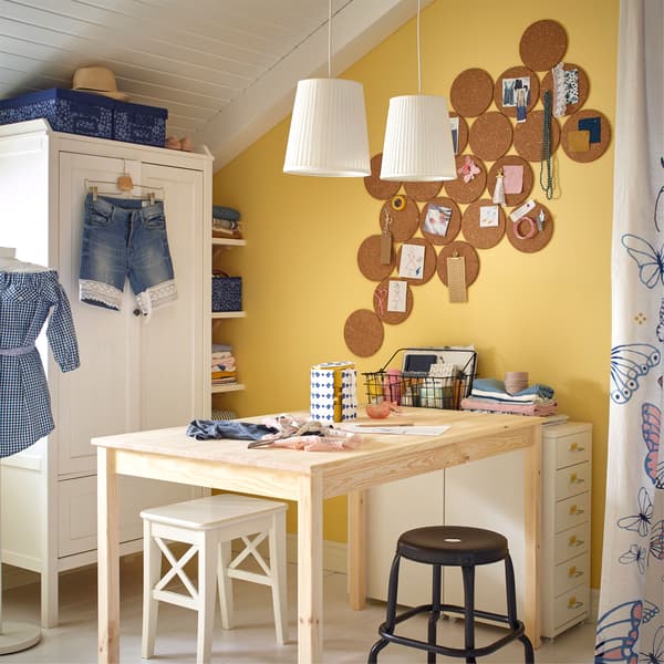 An IKEA INGO untreated pine table used as a DIY work surface, with stools and a HELMER white drawer unit for craft supplies.