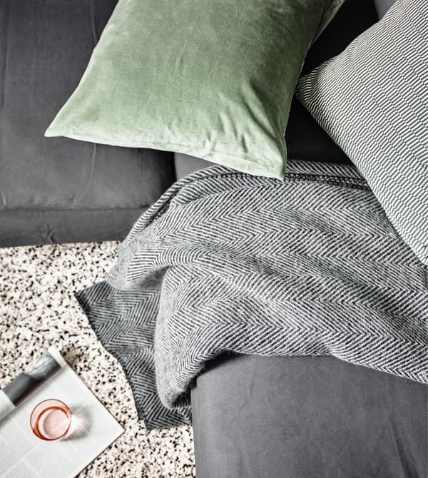 An IKEA STRIMLÖNN wool throw on a sofa