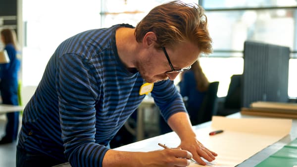 An IKEA Visual Merchandiser draws at his desk.