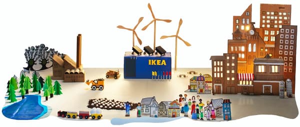 An image of an IKEA community made from recycled materials depicting an IKEA store in the center with windmills made from wood, a city made from cardboard, and the natural environment made from colored paper and children's toys.