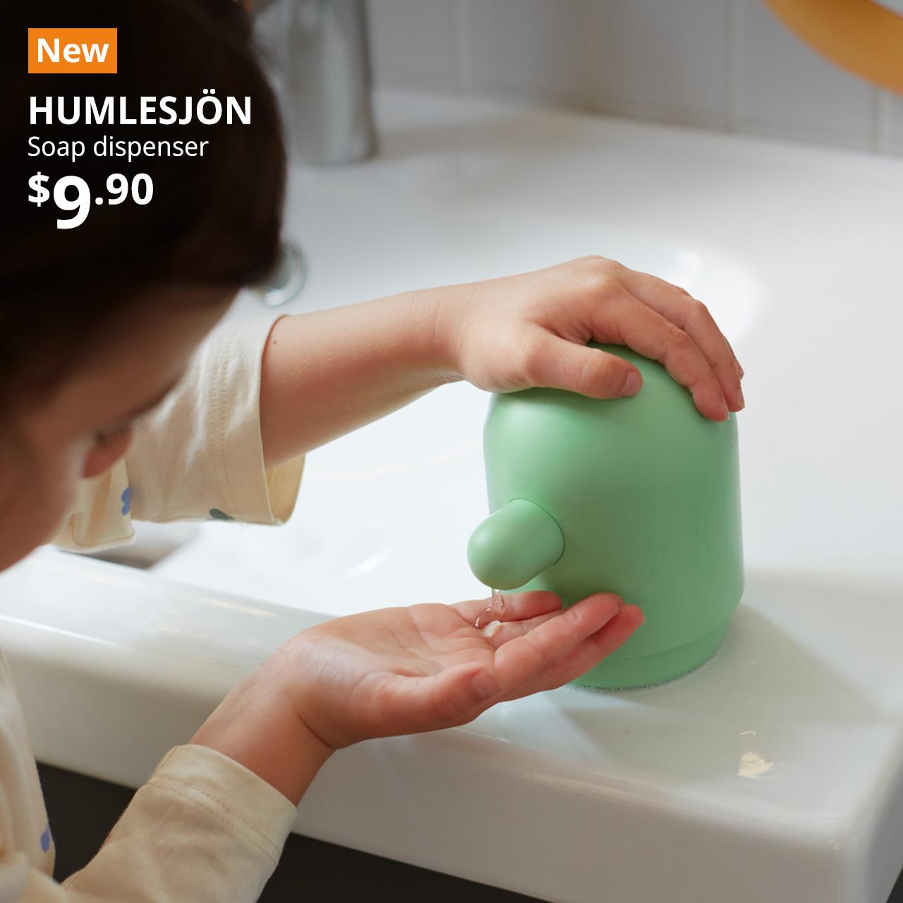 An image showing a child using the light green HUMLESJÖN soap dispenser in a bathroom setting. Text on image reads "New, HUMLESJÖN, Soap dispenser, $9.90"
