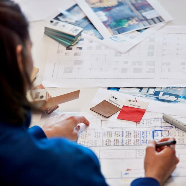 An interior design plan being made, with colours, pictures, and layout sprawled across a table.