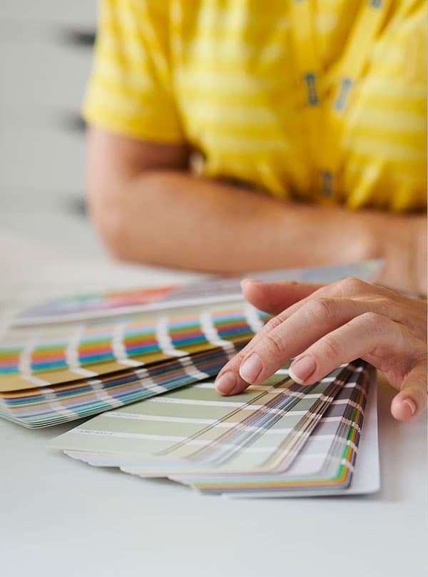 an interior designers hands holding paint color palettes