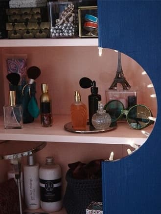 An IVAR cabinet painted pink on the inside and blue on the outside with a circle cut out in the middle to both hide and display.