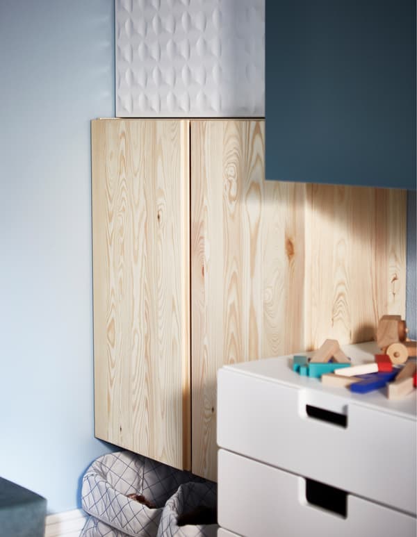 An IVAR cabinet turned into a game and entertainment storage centre with baskets for game controllers, hooks for headphones and magazine files for more storage