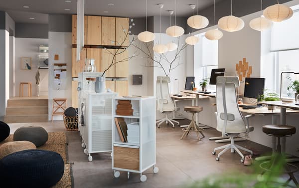 An office furnished with ergonomic IKEA JÄRVFJÄLLET swivel chairs, IVAR pine storage cabinets and BEKANT oak veneer work desks.