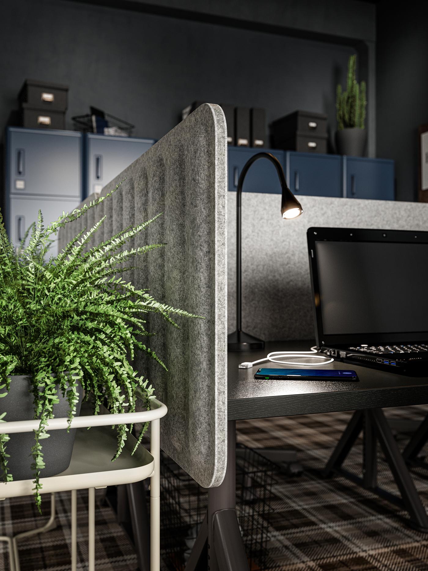 An office interior with EILIF screens in grey attached to a desk with a lit lamp, a laptop and a mobile phone on top.