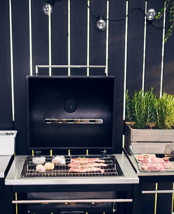 An open barbeque with steaks grilling.