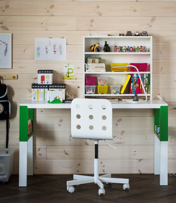 An organized study area for a child that uses a white and green PÅHL desk, a desk shelf unit and see-through boxes with lids to easily store small stuff.