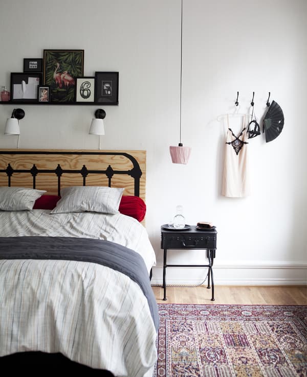 An upside-down lampshade hangs over a bedside table.