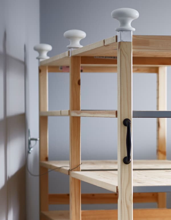 Anchor your IKEA shelf hack to the wall using a bracket and a metal wire.