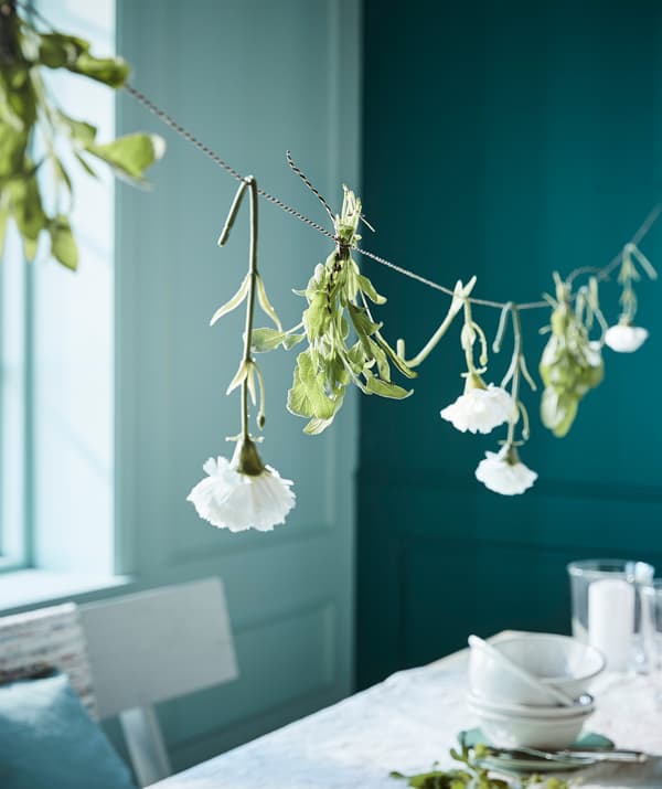 Appendi un nastro sopra la tavola e decoralo con dei fiori. Da IKEA trovi il nastro GIVANDE, disponibile in nero, nero/beige e bianco.