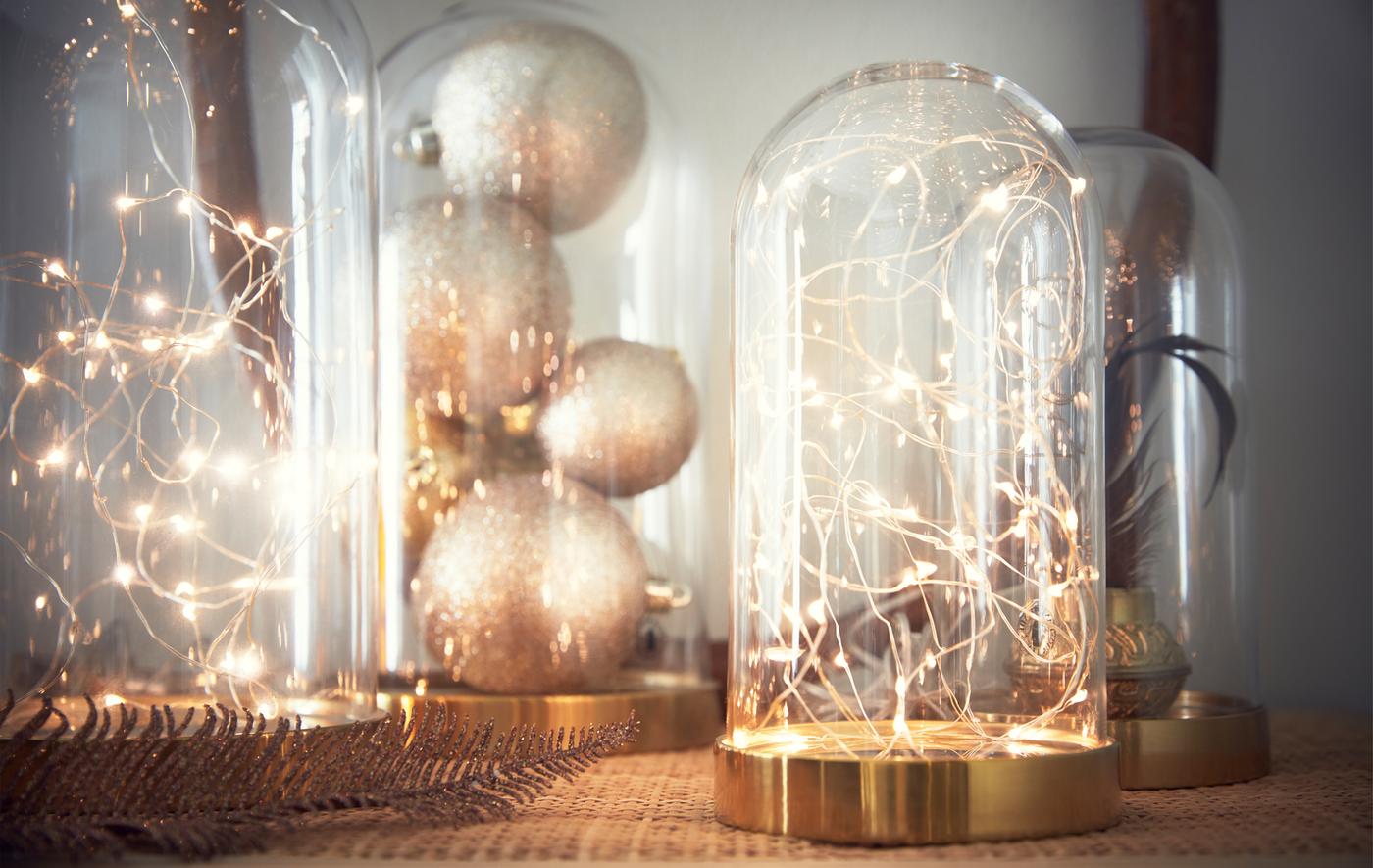 Arrangement of different items in glass domes, including string lights and Christmas decorations.