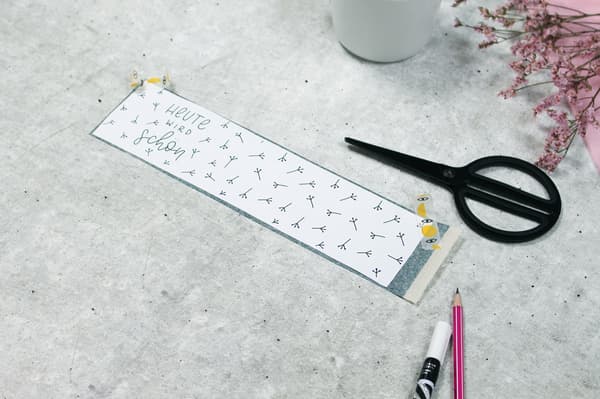 Auf diesem Bild sieht man auf dem Tisch die Schere und das Papier liegen das man zuvor ausgeschnitten hat.