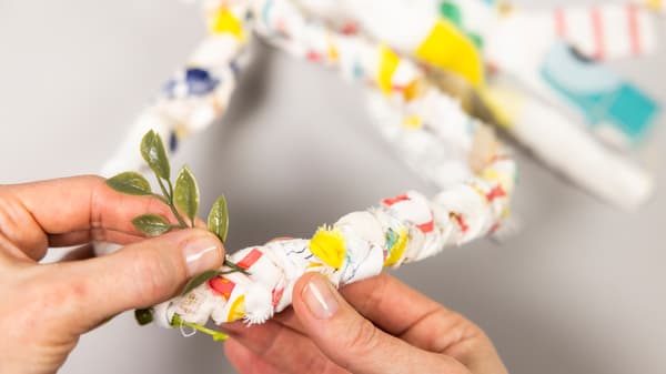 Aus dem Stoff macht sie einen Kreis  und bindet es zusammen und steckt kleine grüne Blätter hinein.