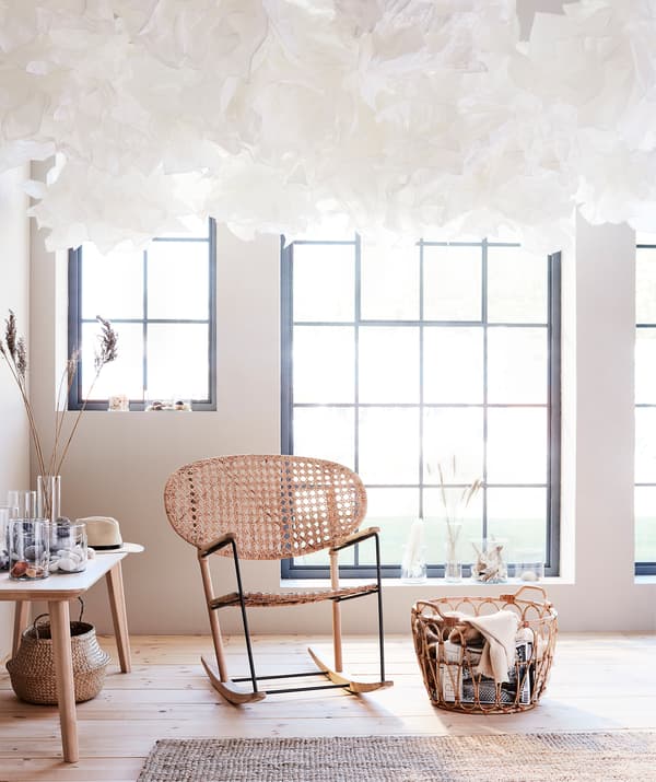Avec un plafond constellé de KRUSNING, impossible de ne pas lever les yeux au ciel! Un fauteuil à bascule GRÖNADAL et un panier en rotin SNIDAD complètent ce petit coin cosy.