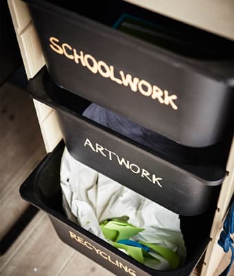 Bacs TROFAST bien identifiés et recevant travaux scolaires, projets d’art et matières recyclables.