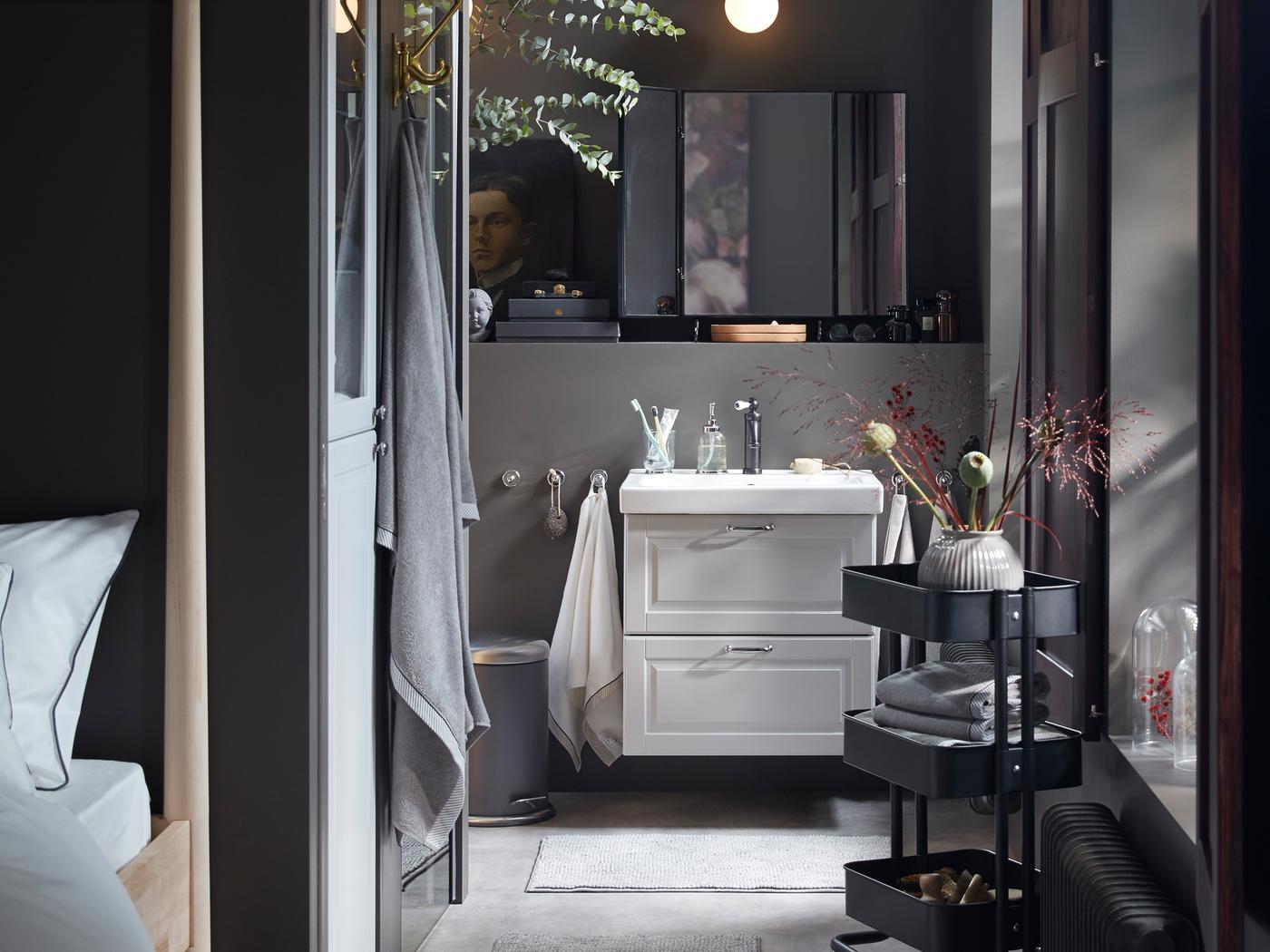 Badezimmer mit einem ODENSVIK Waschbecken, einem GODMORGON Waschbeckenschrank mit zwei Schubladen und einer FRIHULT Wandleuchte.