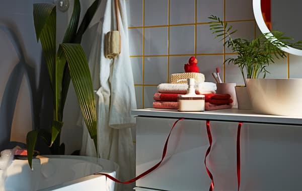 Bathroom interior focusing on a GODMORGON wash-stand with the loose ends of a gift ribbon hanging out from the top drawer.