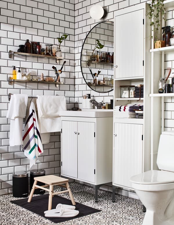 Bathroom with white SILVERÅN washstand and cabinets, and wall-mounted BROGRUND glass shelves: one for him and one for her.
