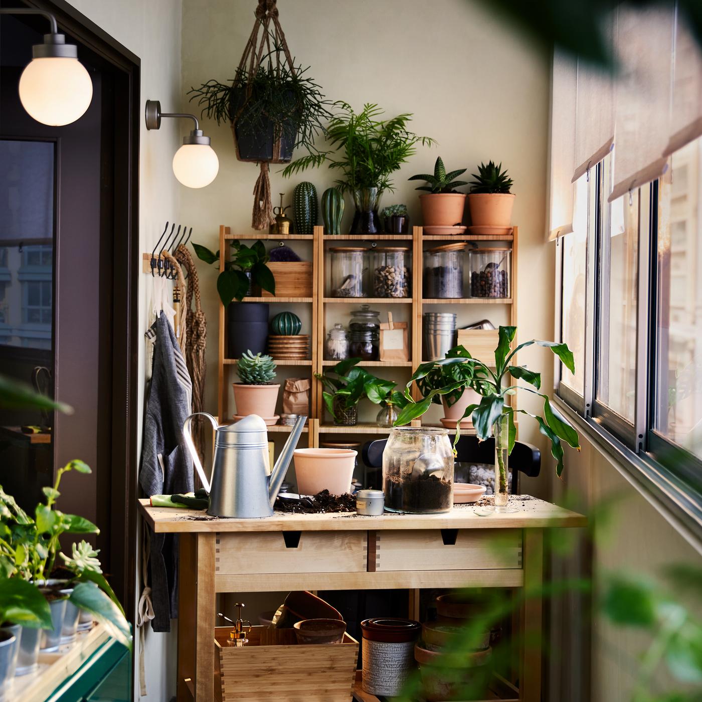 バーチ材製のFÖRHÖJA/フォルホイア キッチンワゴン、竹製のシェルフユニット、グリーンのキャビネット。いたるところに植物やガーデニング用品が置いてある。