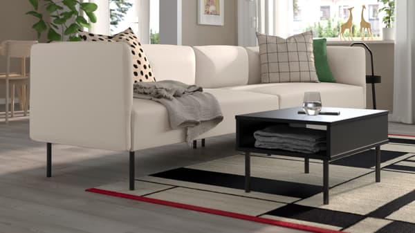 Beige LILLEHEM 3-seater sofa in a neutral-toned living room, featuring a black coffee table and decorative cushions.