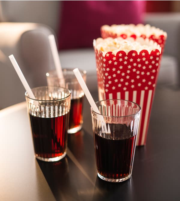 Beverages and popcorn sit on a coffee table.