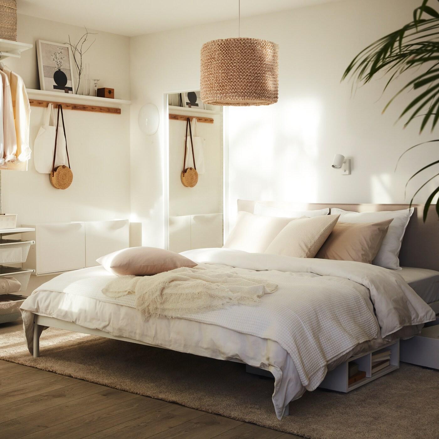 Bilik tidur yang terang yang mempunyai katil KLEPPSTAD dengan linen katil ÄNGSLILJA berwarna putih dan lampu LERGRYN tergantung di atasnya.