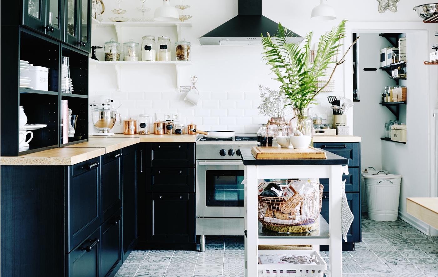 Black and white kitchen with pantry area packed with storage solutions.