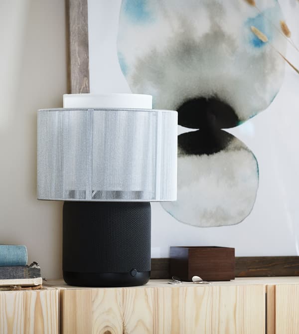Black and white SYMFONISK on a pine sideboard.